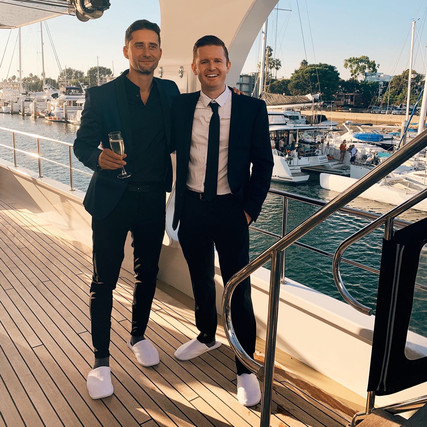 Patrick Bushe in a suit on a yacht with other guests