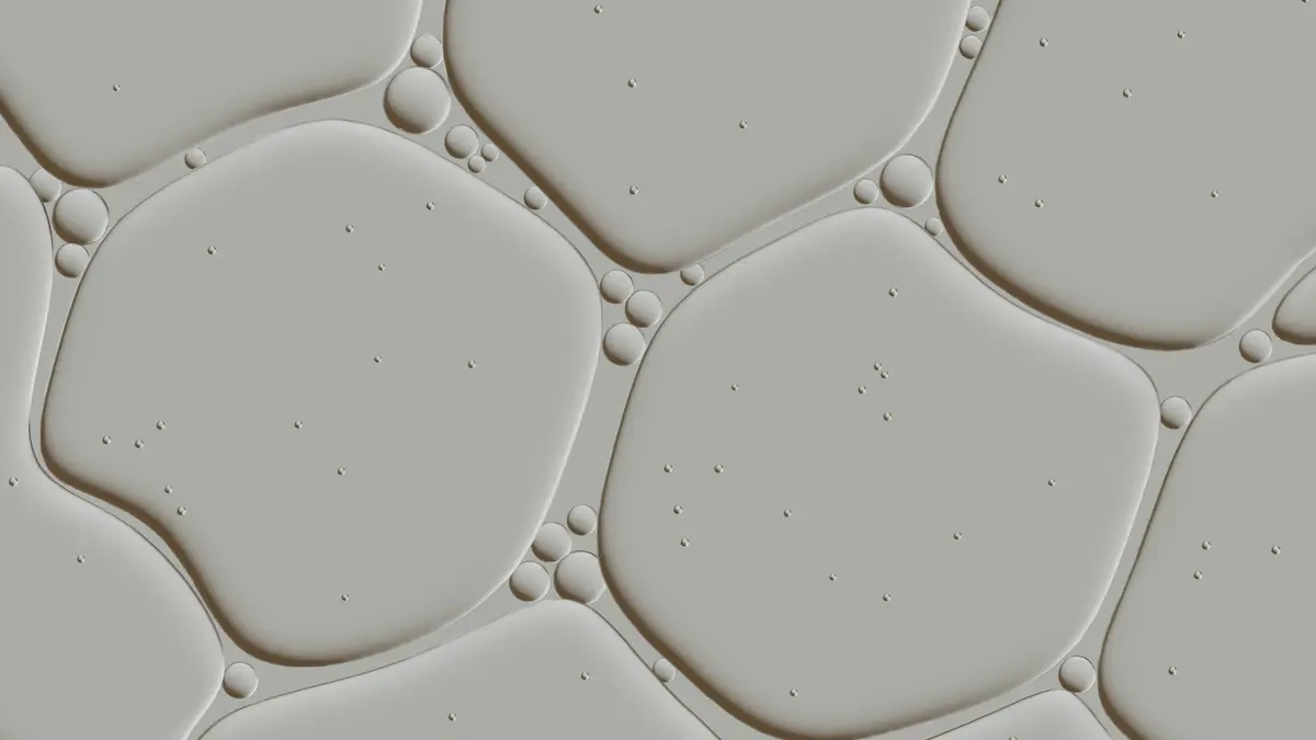 Clear droplets of serum on a grey surface