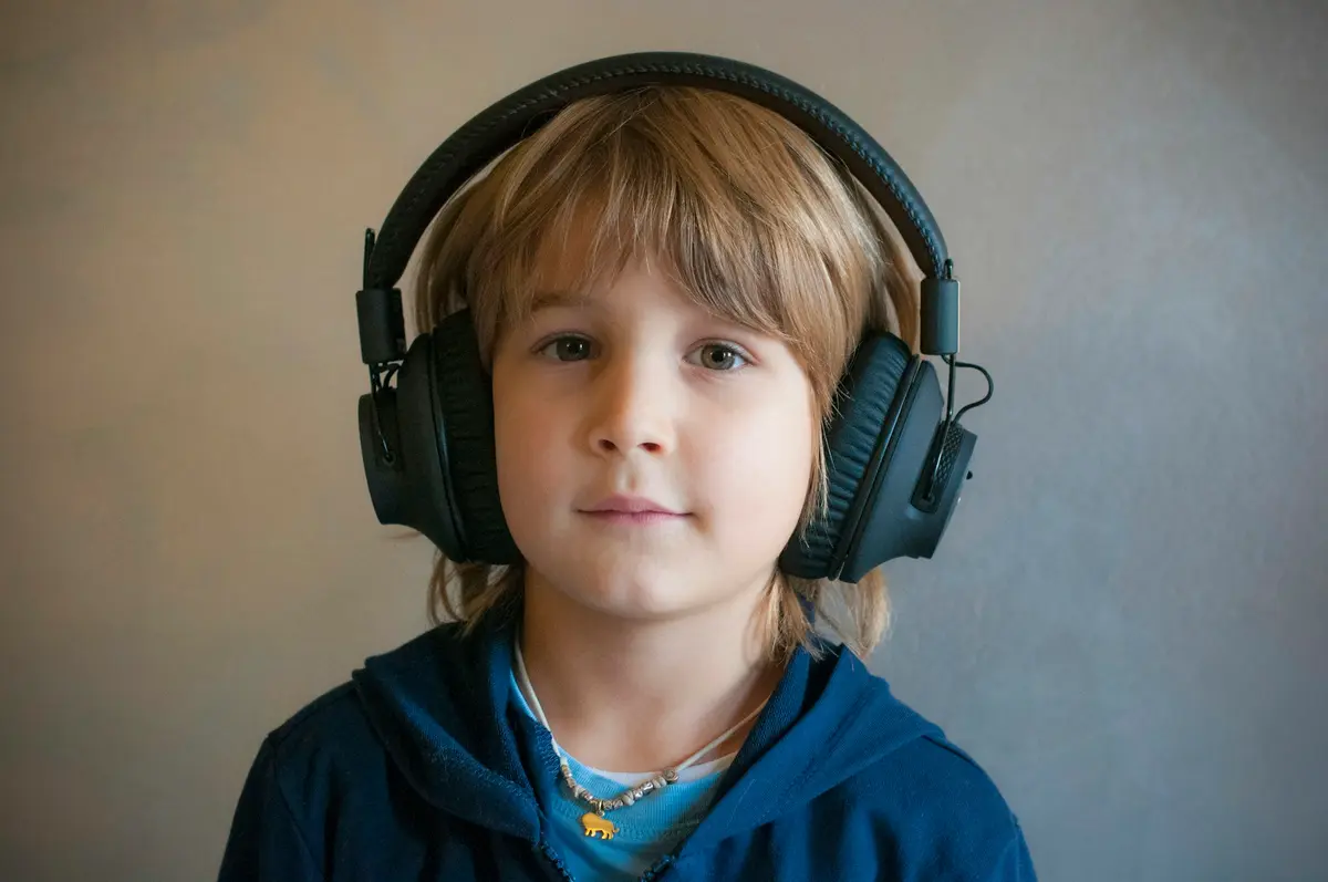 A child wearing big headphones, relaxed