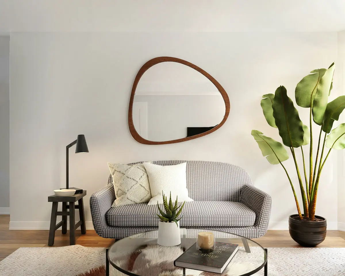 A grey sofa under a round mirror