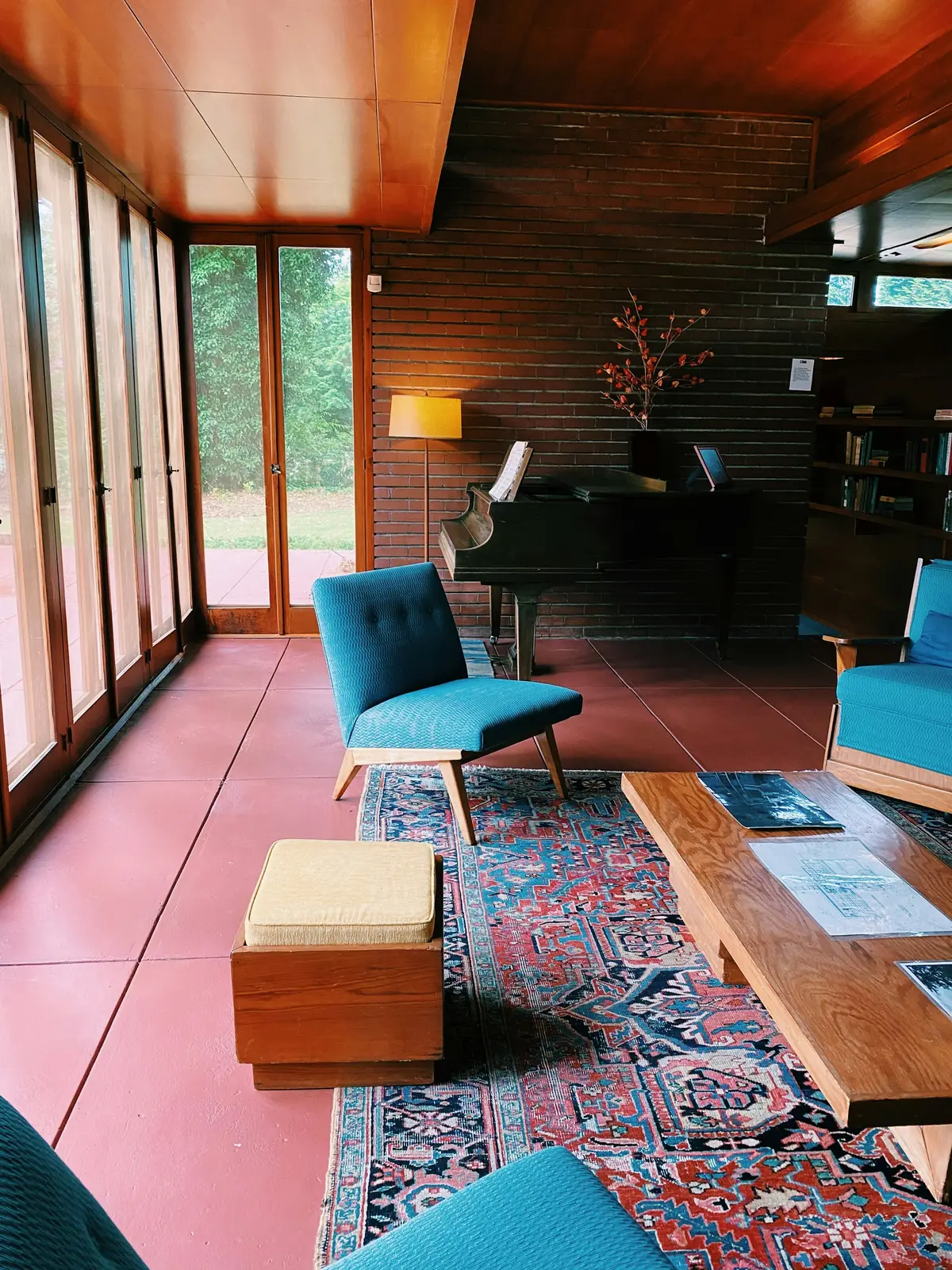 Living room with a red concrete floor and walls of glass