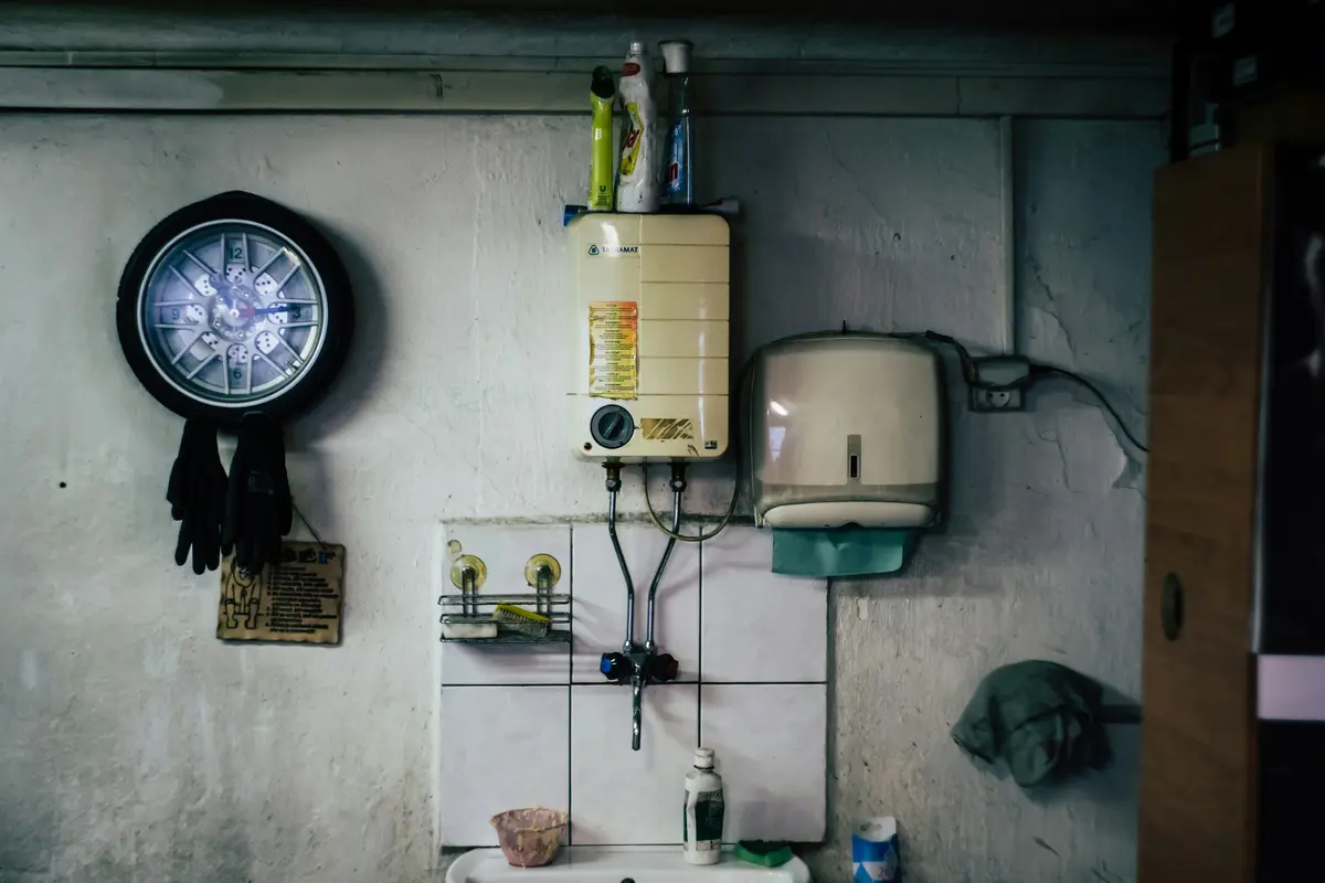 A tankless water heater and a clock on a concrete wall
