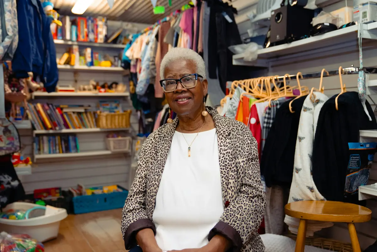 A shop owner sitting in her clothing store