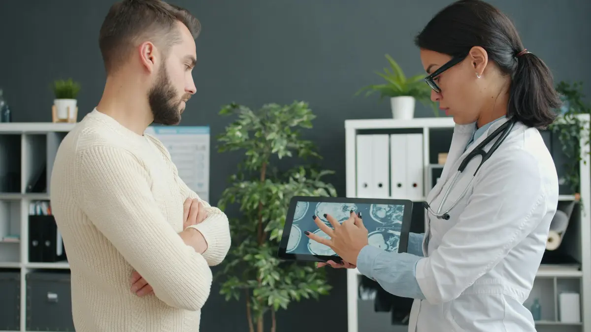 A clinician shows a patient a scan on a tablet