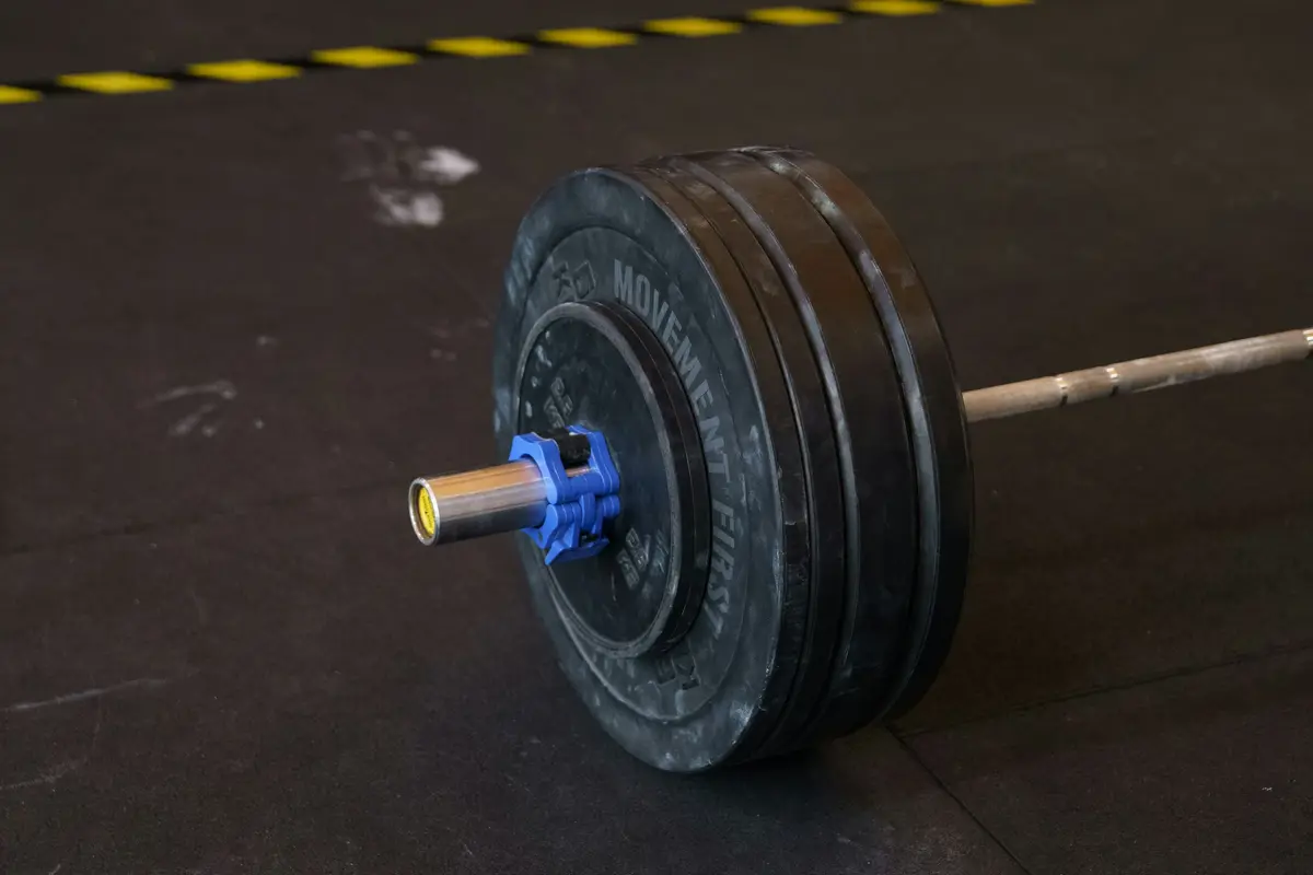 A loaded barbell resting on a gym floor