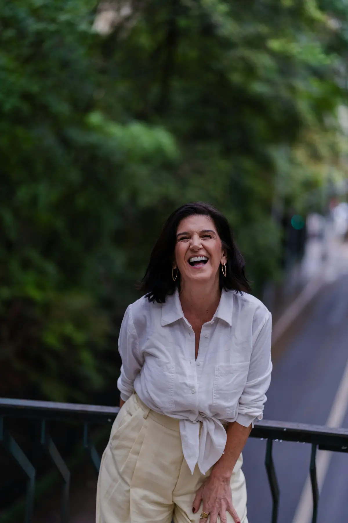 An adult laughing outdoors