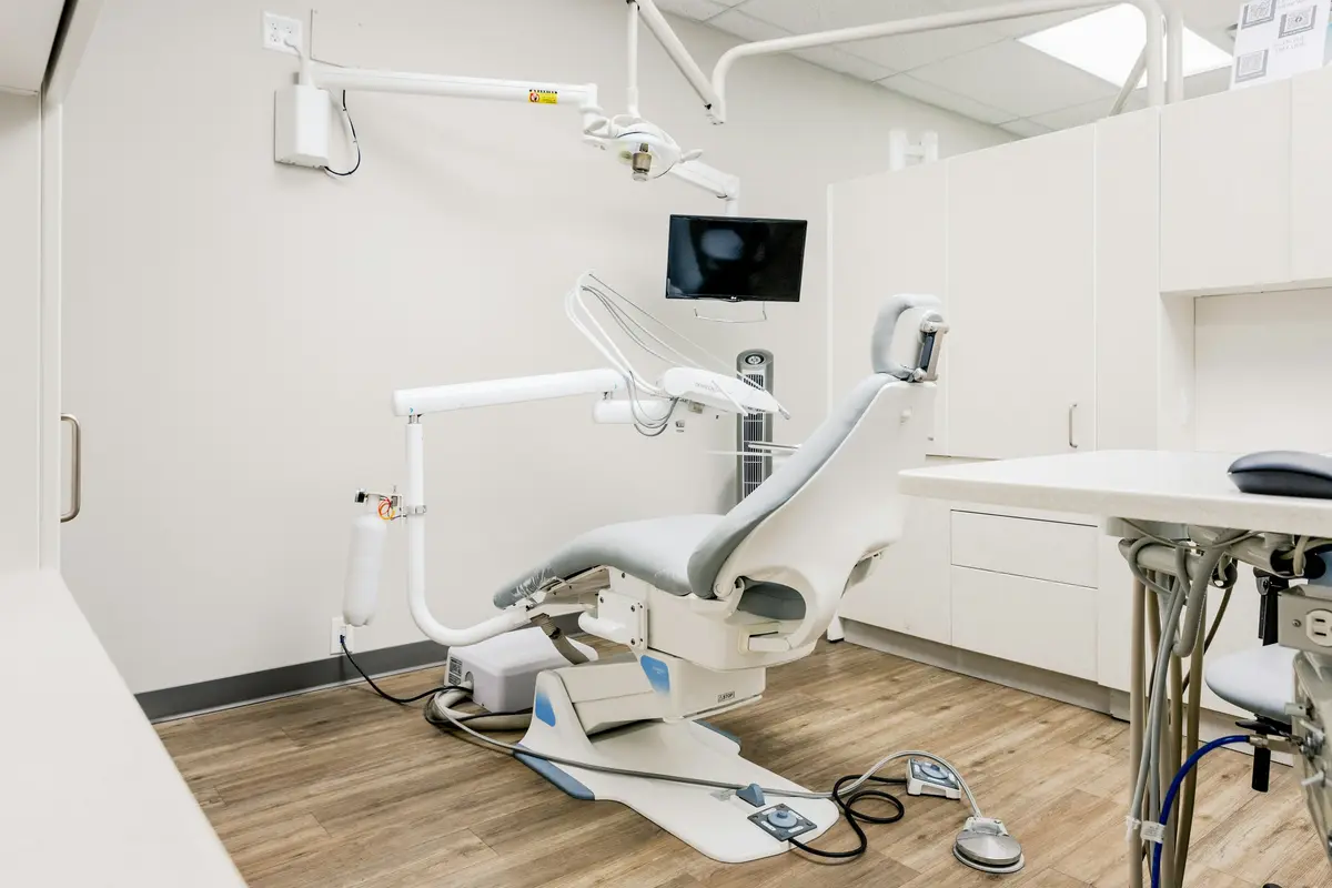 A bright, white treatment room with a dental chair