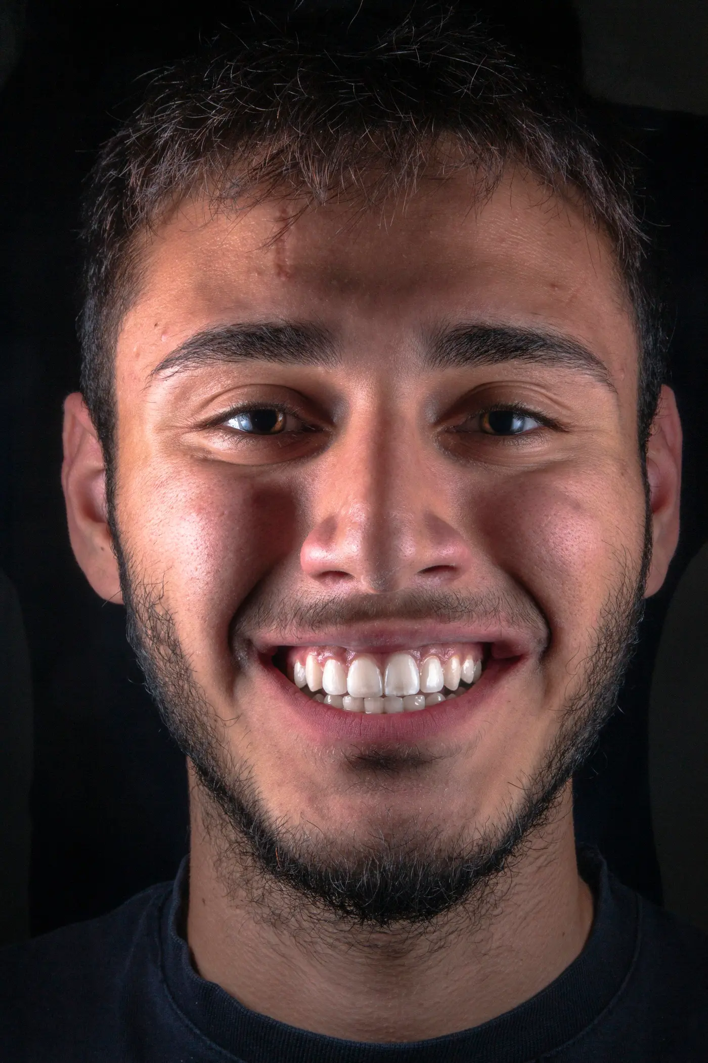 A young man with a wide, straight smile