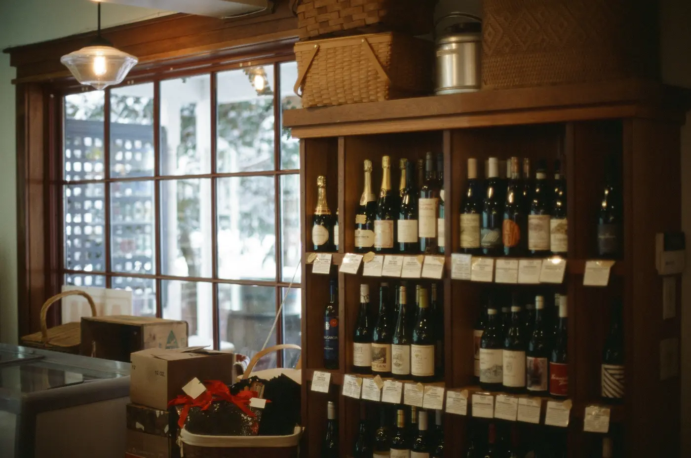 Inside a small wine shop with shelves of bottles under the window