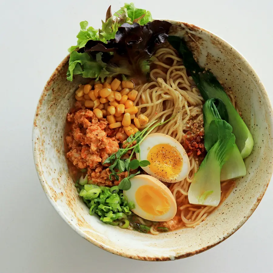 A spicy tantan ramen with ground pork, egg and bok choy