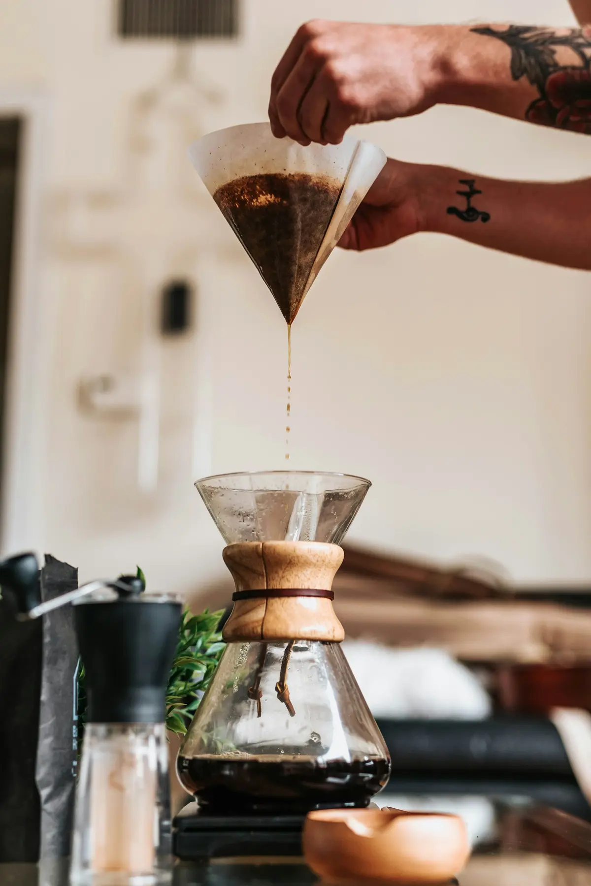 Coffee dripping through a paper filter into a glass Chemex