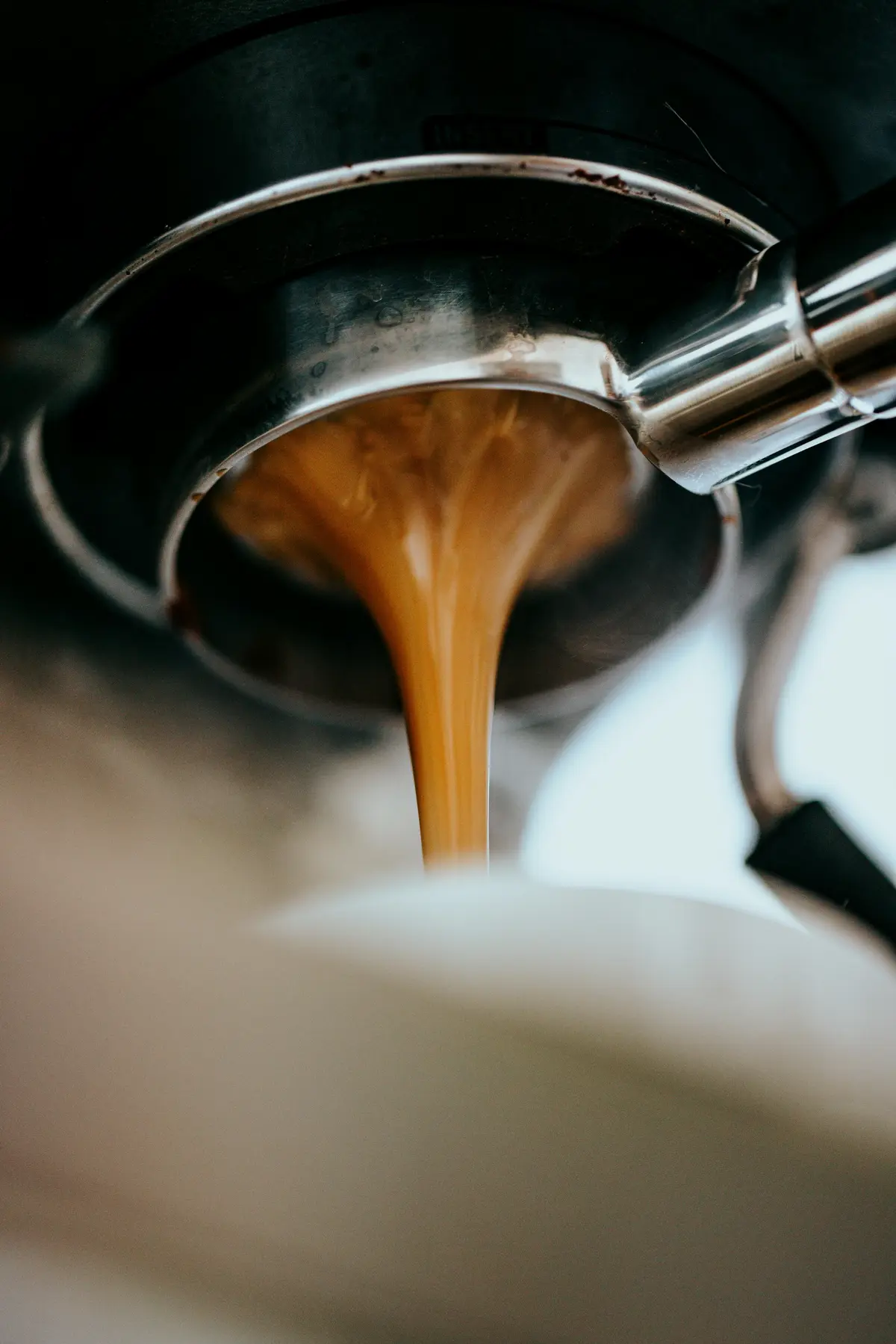 Espresso pouring from a portafilter into a cup
