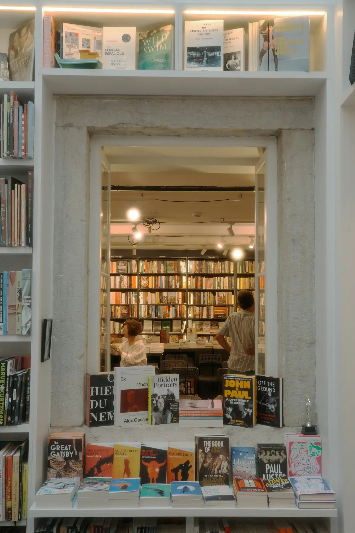 The open door of a small bookshop with shelves and a front table of new books