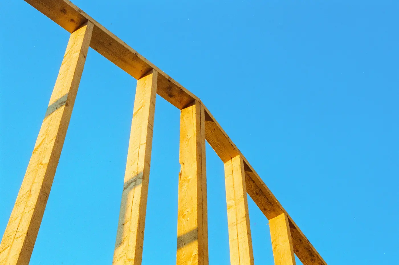 New wall studs standing against a blue sky