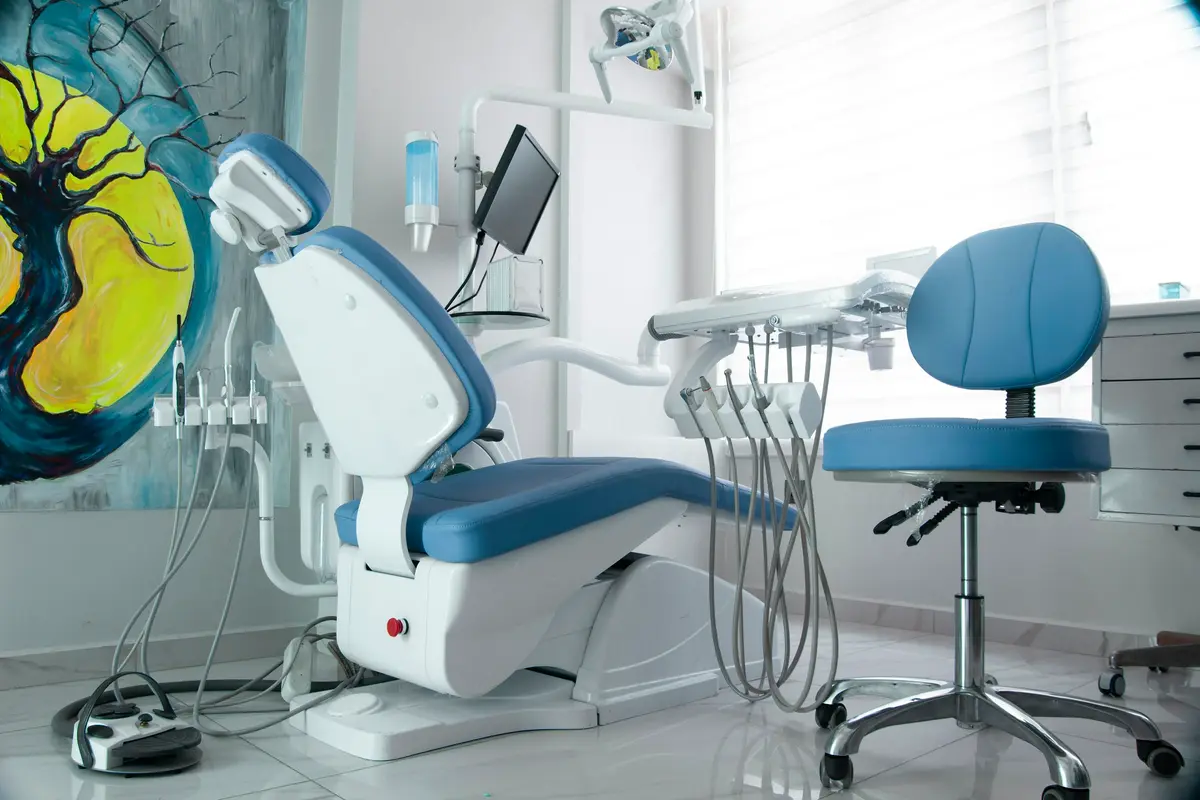 A blue dental chair in a bright treatment room