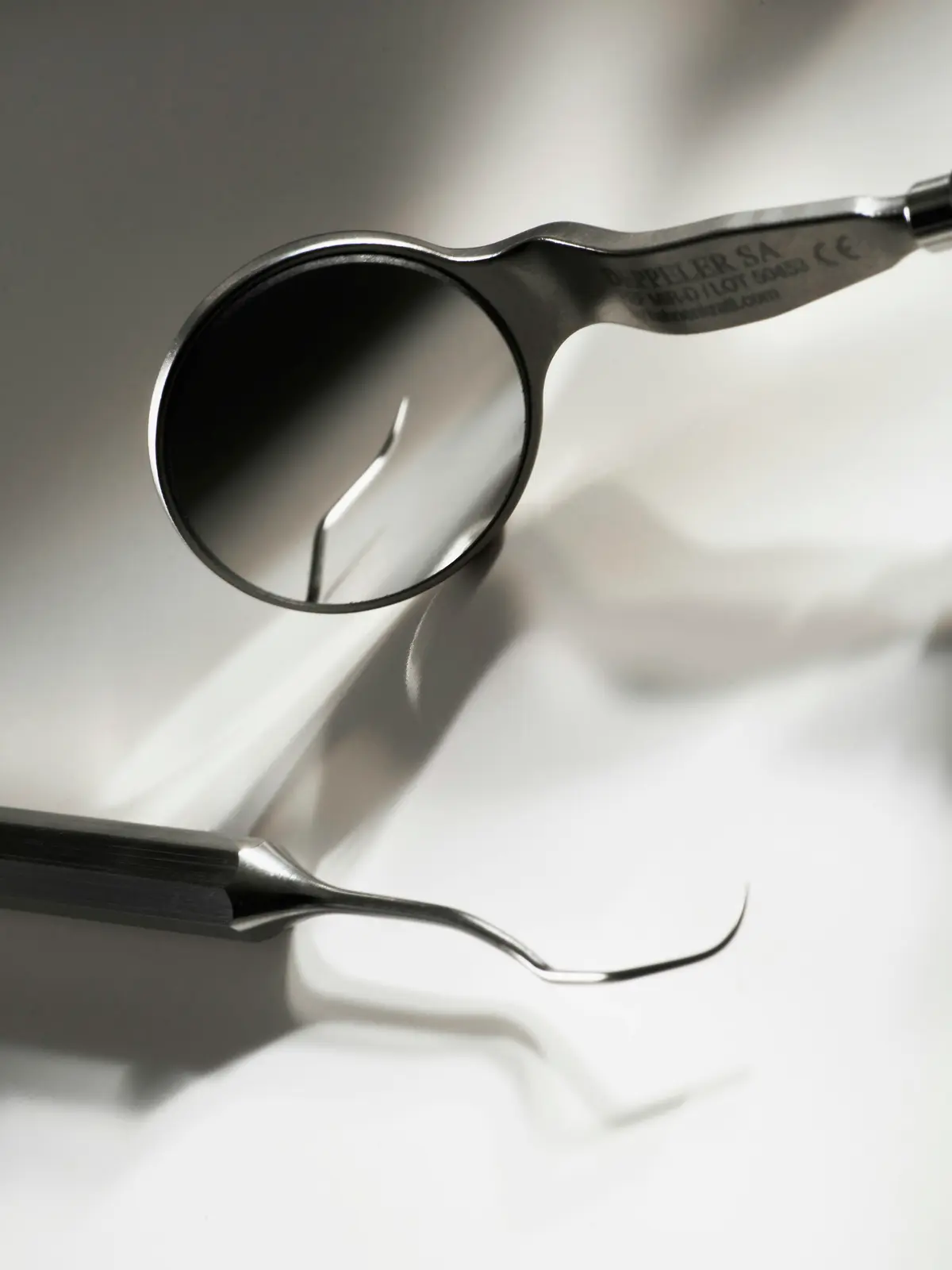 A dental mirror and probe on a white tray