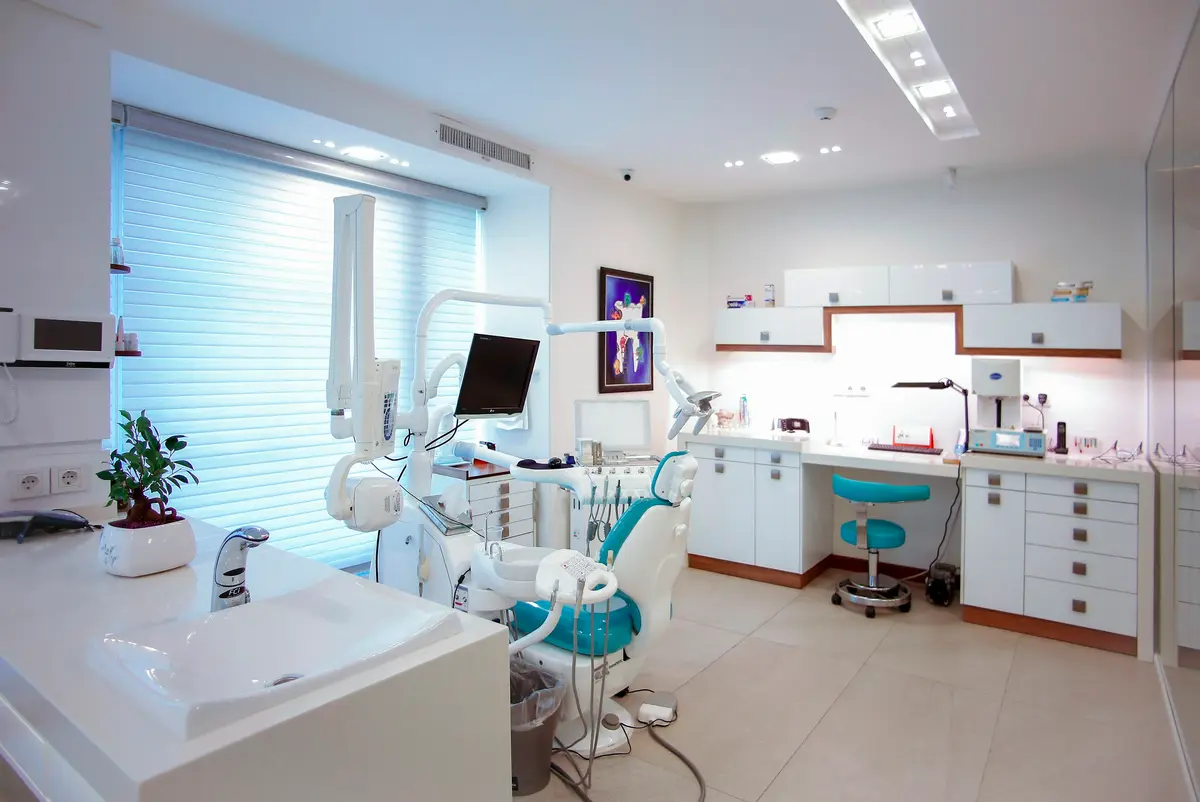 A bright treatment room with a dental chair by a window